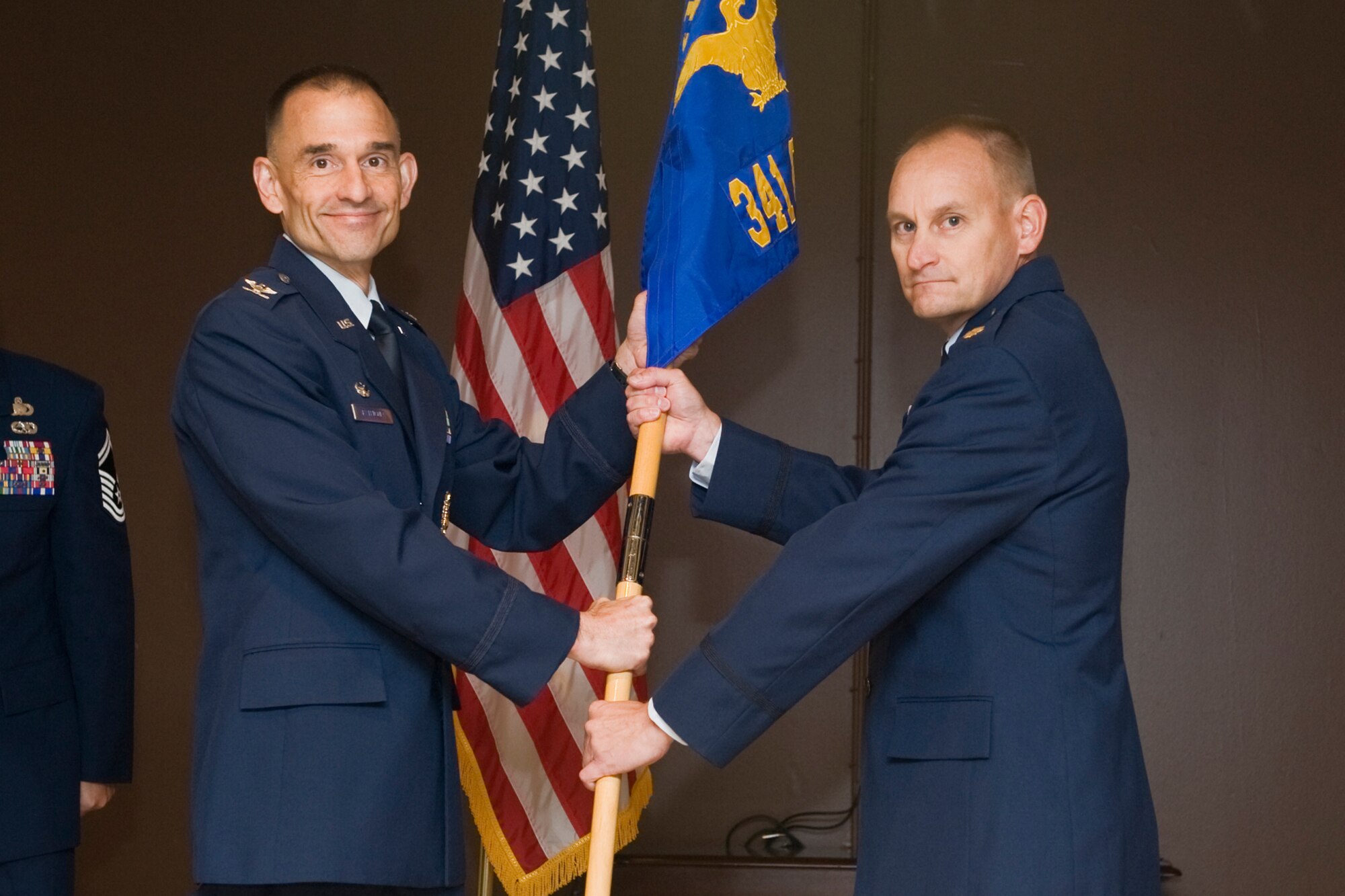 Maj. Daryl Nuutinen accepts command of the 341st Contracting Squadron from Col. John Patricola, 341st Mission Support Group commander, Aug. 30 during an assumption of command ceremony at the Grizzly Bend Community Center. (U.S. Air Force Photo/Beau Wade)