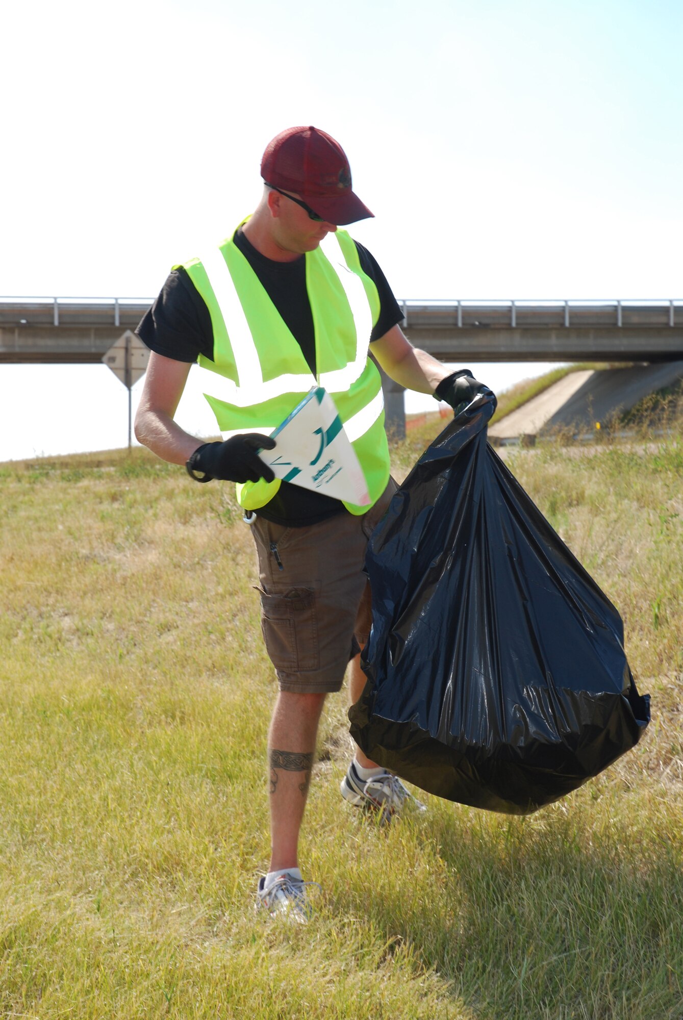 Staff Sergeant Brant Riley, 341st Civil Engineer Squadron engineering draftsman, picks up trash and debris during the Air Force Sergeants Association Adopt-a-Highway clean up Aug. 27. More than 20 volunteers assisted in picking up more than 800 pounds of trash down the two mile stretch along Highway 15. The Top 3 organization held their highway clean-up on Aug. 28. (U.S. Air Force photo/Airman 1st Class Kristina Overton)