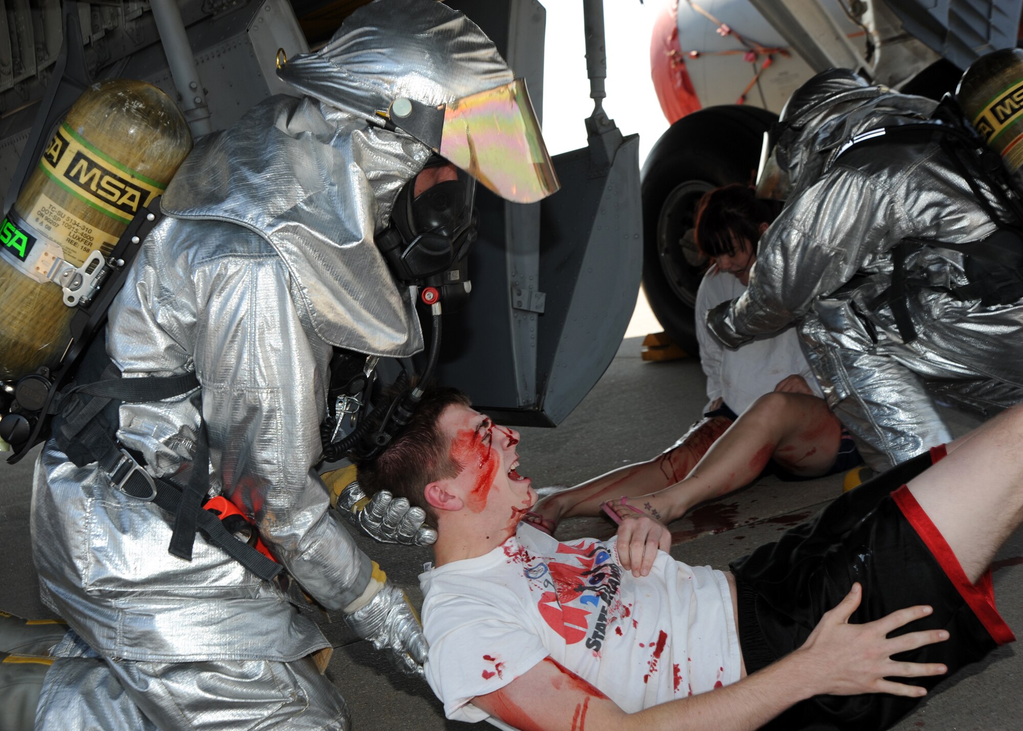 A firefighter assists an “injured” exercise victim from a simulated plane crash during an exercise scenario Sept. 1, 2010, McConnell Air Force Base, Kan.  The training exercise tested the Team McConnell’s ability to respond to a major accident.  McConnell’s Airmen and community members participated as “casualties” to help increase the realism of the exercise.  (U.S. Air Force photo/Airman 1st Class Andrea Salazar)