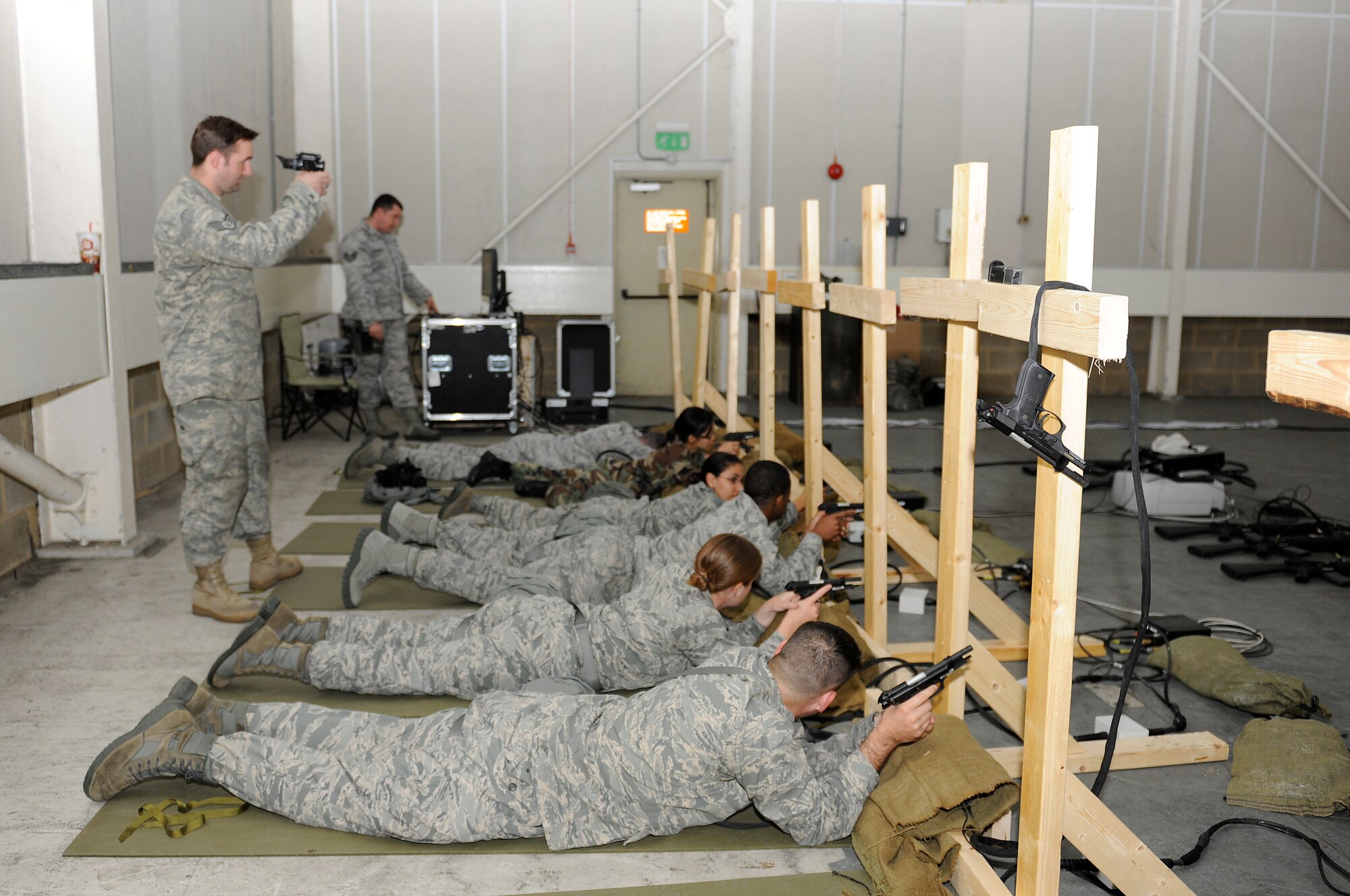 Staff Sgt. Joshua Sampson, 48th Security Forces Squadron training NCO (left), observes targets on the Engagement Skill Trainer 2000 with night vision goggles Sept. 1, 2010, at RAF Lakenheath. Night-vision goggles allow the viewer to see what each individual is aiming at on the virtual firing range. (U.S. Air Force photo/Airman 1st Class Lausanne Morgan)
