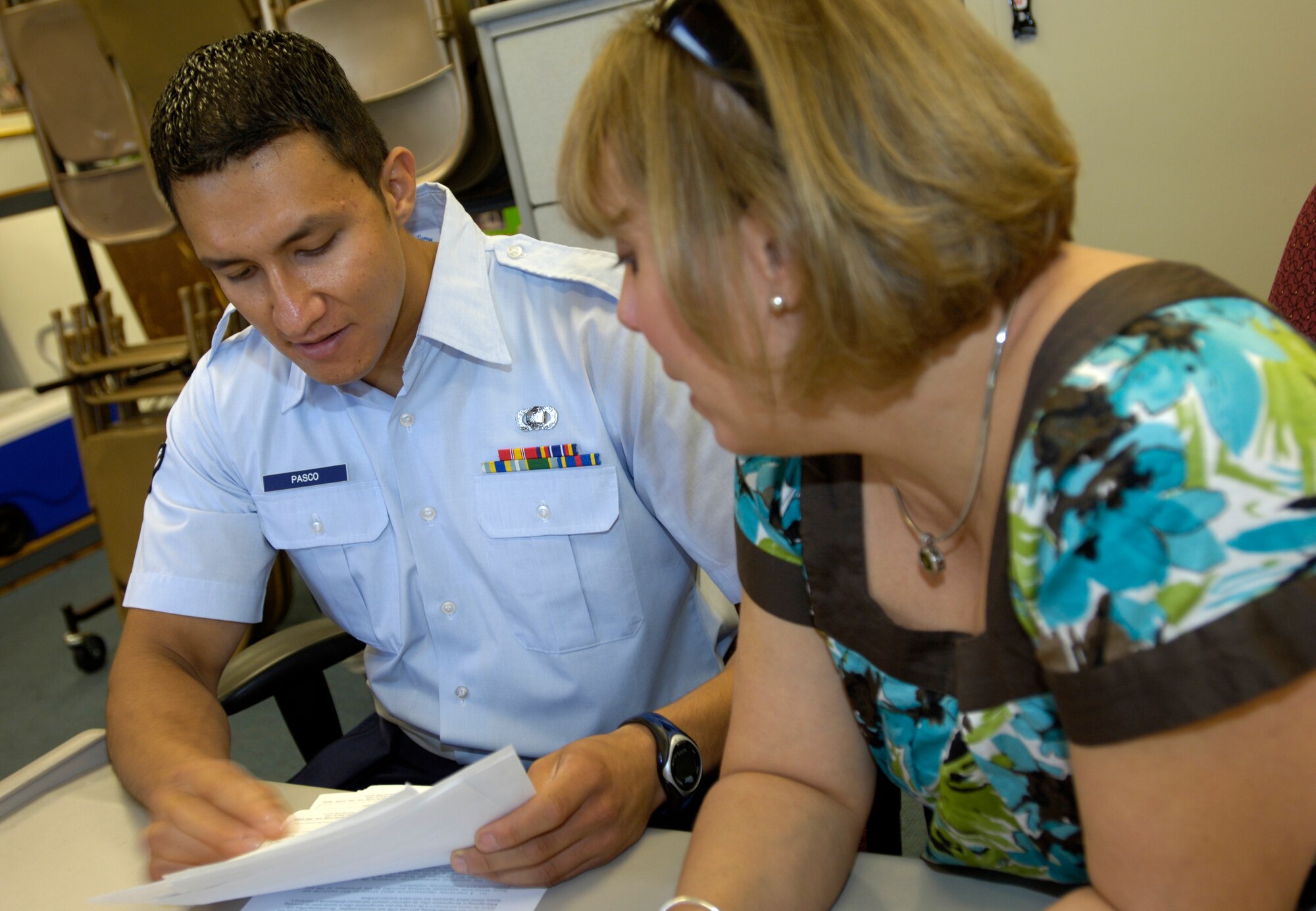 Airman 1st Class Christopher Pasco, 22nd Contracting Squadron contracting specialist, discusses a contract with Elizabeth Lee, 22nd Force Support Squadron family services coordinator. Airman Pasco manages, performs and administers contracting functions for commodities, services and construction at McConnell. At any one time, the Brattleboro, Vt., native can have up to 45 contracts on his desk. (U.S. Air Force photo/Airman 1st Class Armando A. Schwier-Morales)