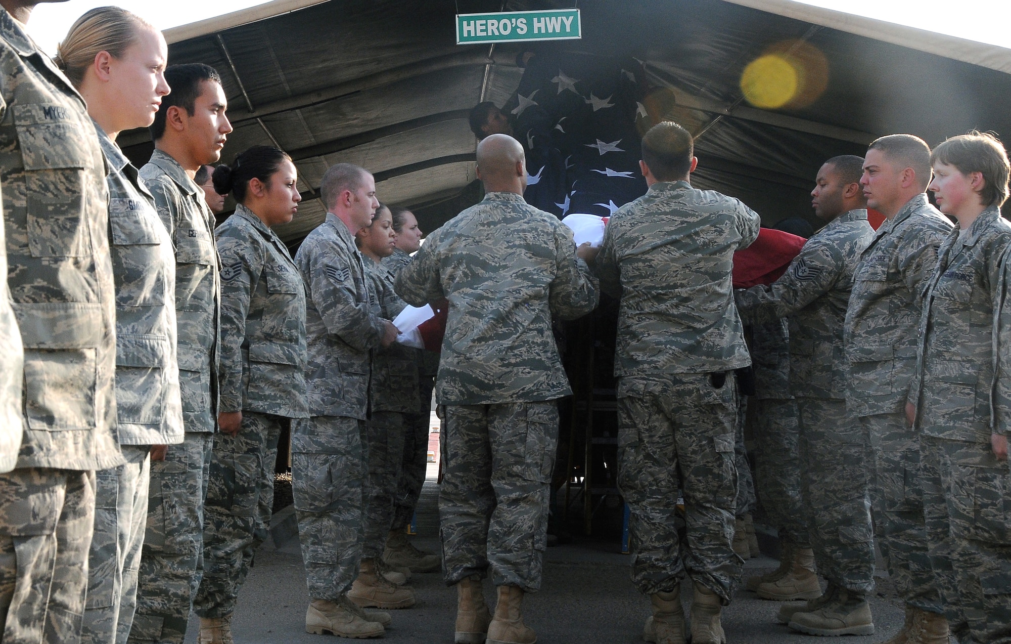 Members of the 332nd Expeditionary Medical Group Color Guard unfold a new flag while placing it in its proper place at Hero’s Highway Sept. 1, 2010, Joint Base Balad, Iraq. “This is the perfect time to change the flag as our focus also changes,” said Col. John Mitchell, 332 EMDG commander.  “We have taken down the flag associated with combat operations and the way things were. We are now focusing on ‘train the trainers,’ as we train and turn over control to the Iraqi army in preparation for Dec. 31, 2011.” (U.S. Air Force photo/Senior Airman Marianne E. Lane)