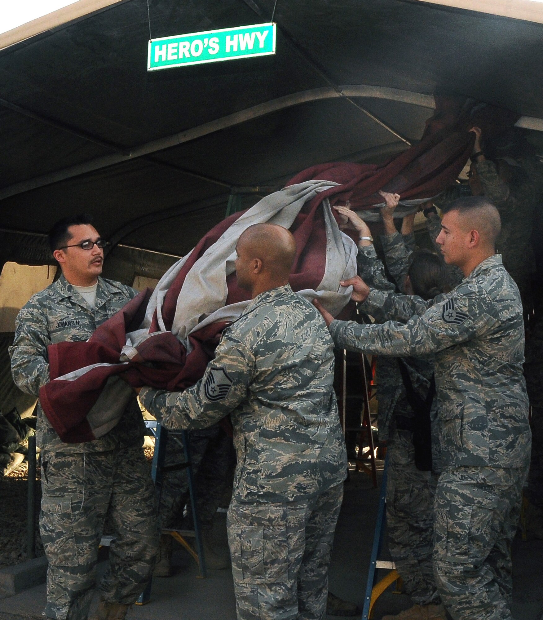 Members of the 332nd Expeditionary Medical Group Color Guard take down the American Flag at Hero’s Highway Sept. 1, 2010, Joint Base Balad, Iraq. This flag, taken down during the first day of Operation New Dawn, is the fifth Hero’s Highway flag since 2004. (U.S. Air Force photo/Senior Airman Marianne E. Lane)