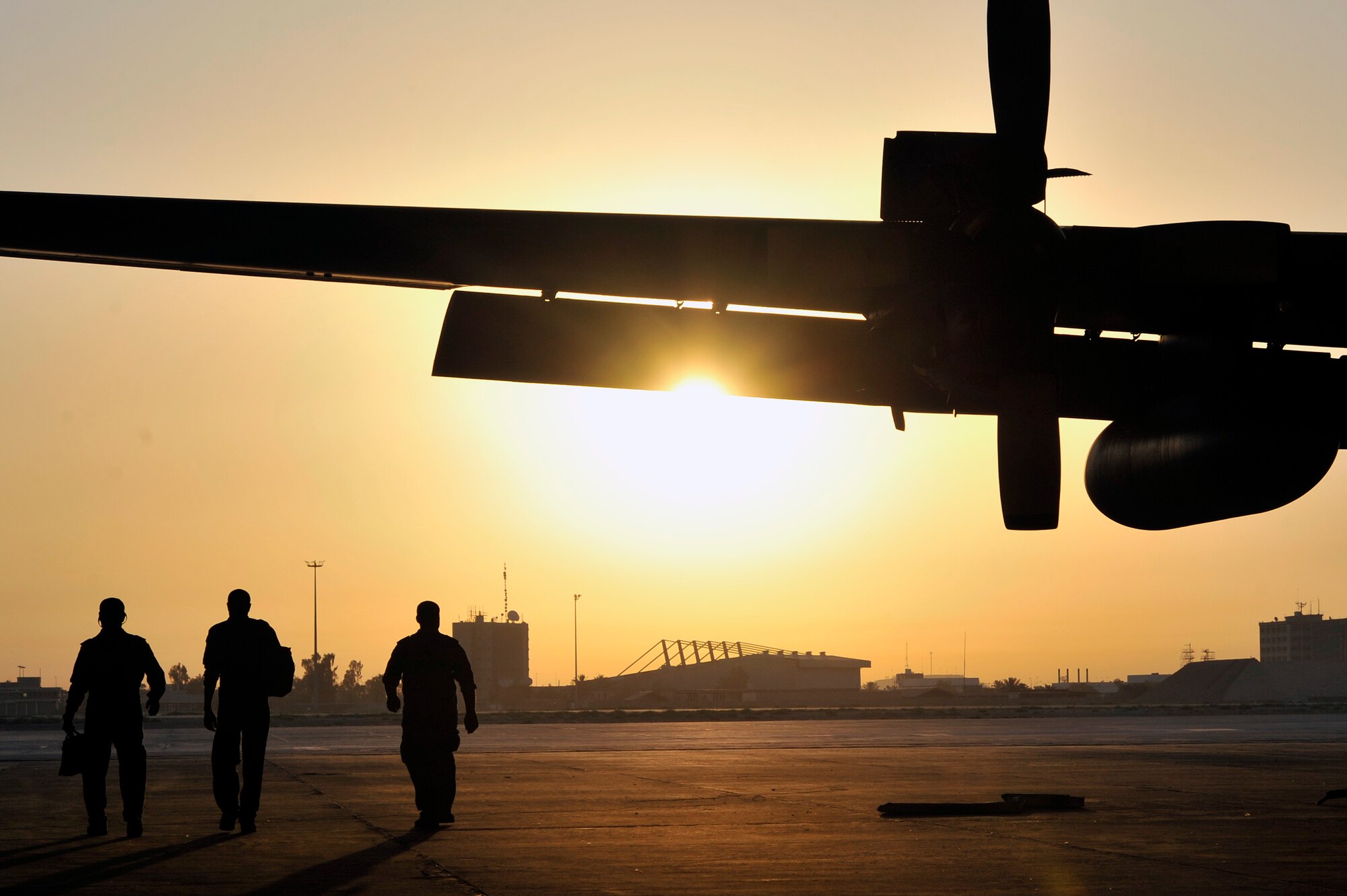 Iraqi Air Force airmen walk past an IAF C-130 Hercules to their C-12 Huron equipped with intelligence, surveillance and reconnaissance equipment, at New Al Muthanna Air Base, Iraq.The U.S. Military transitioned from Operation Iraq Freedom to Operation New Dawn on Sept. 1st. As part of Operation New Dawn, U.S. Forces have three primary missions: advising, assisting, and training the Iraqi Security Forces; conducting partnered counterterrorism operations; and providing support to provincial reconstruction teams and civilian partners as they help build Iraq's civil capacity. (U.S. Air Force photo by Senior Airman Perry Aston)