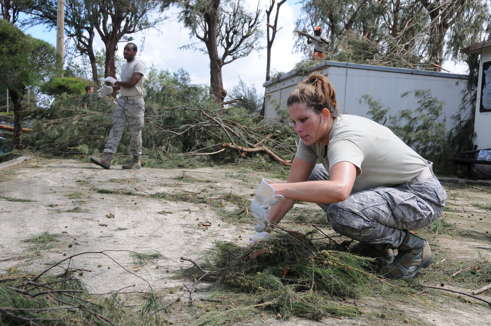 Airman 1st Class Lami Powlesland, 18th Aeromedical Squadron, gathers leaves while Airman William Odom, 18th Medical Operations Squadron, goes back for more debris at the Okuma Recreation Area, Sep. 2, 2010. More than 100 Airmen from Kadena Air Base volunteered to help clean up the debris caused by typhoon Kompasu. (U.S. Air Force photo/Staff Sgt. Darnell T. Cannady)