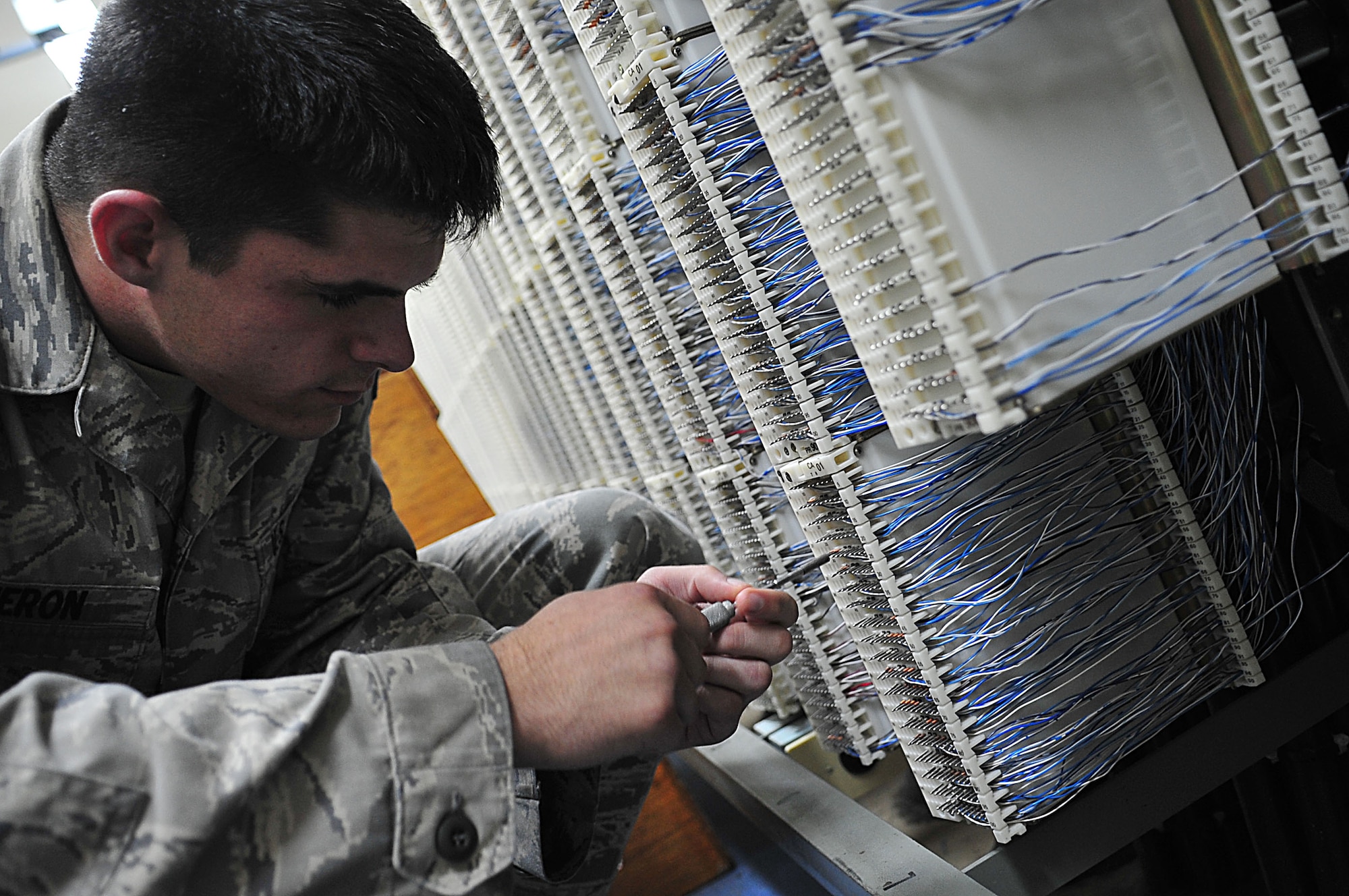 Airman 1st Class Jeffrey Cameron, a member of the 18th Communications Squadron, changes a cable pair on Kadena AB, Japan, Aug. 26. The 18 CS, along with the 18th Civil Engineer Squadron and 18th Security Forces Squadron, recently teamed up to improve the base’s alarm system. (U.S. Air Force photo/Staff Sgt. Alesia Goosic) 