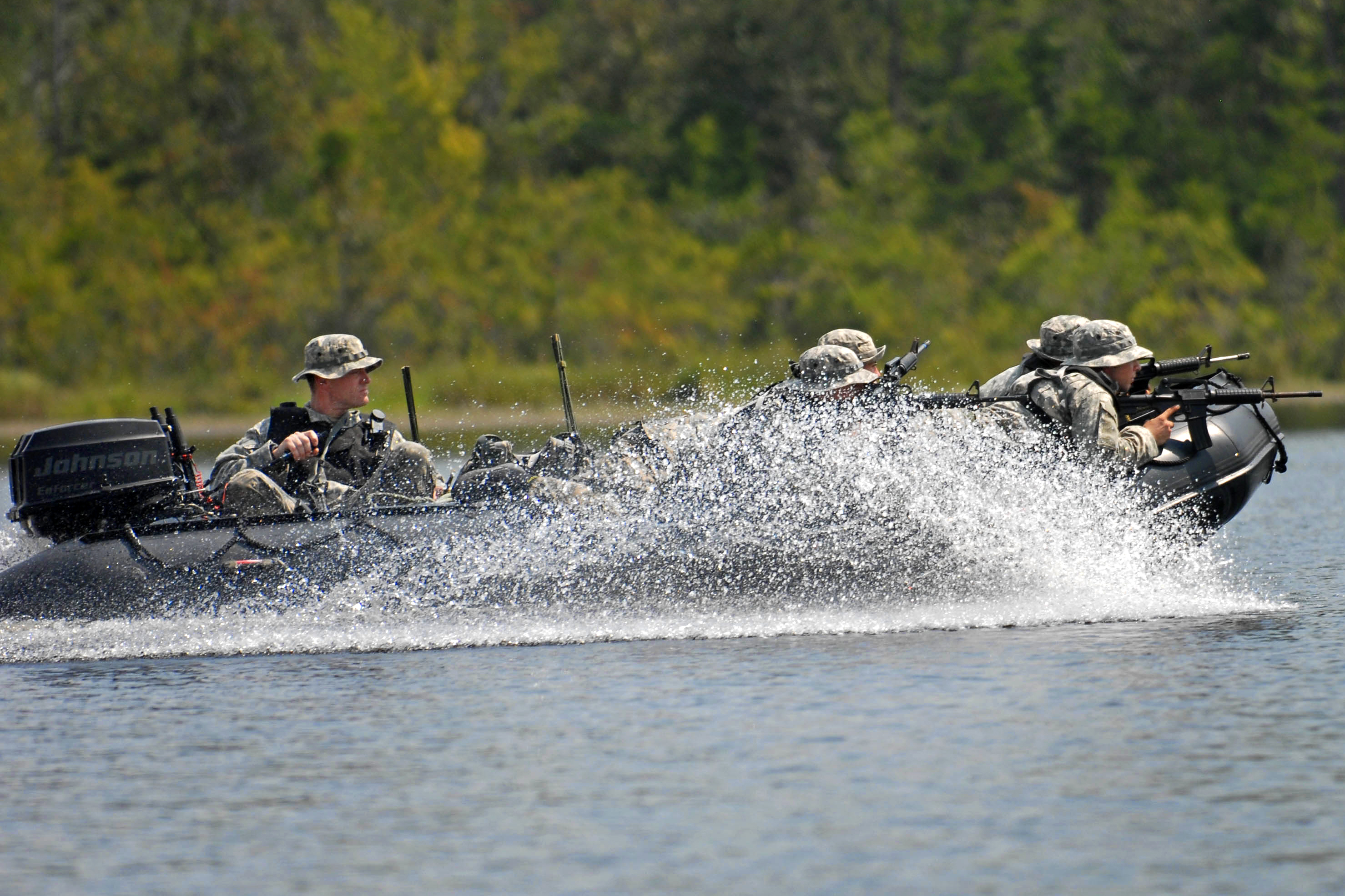U.S. Army soldiers ride in a zodiac boat across Mott Lake to their next