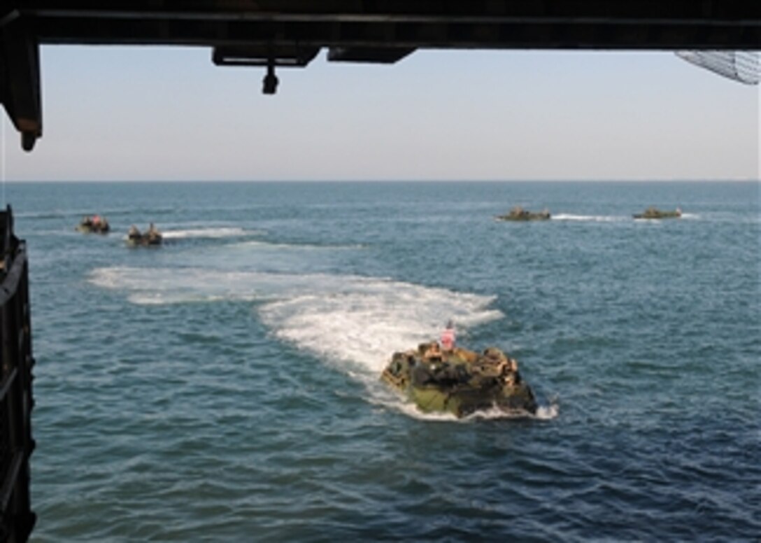 U.S. Marine Corps amphibious assault vehicles prepare to enter the well deck of the amphibious dock landing ship USS Carter Hall (LSD 50) while the ship is underway in the Atlantic Ocean on Aug. 30, 2010.  The Kearsarge Amphibious Ready Group is en route to Pakistan to provide flood relief assistance to residents of that nation.  