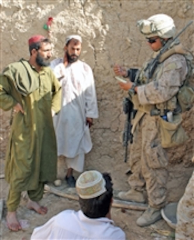 U.S. Marine Corps Cpl. Daniel B. Wyss, a squad leader with Golf Company, 2nd Battalion, 9th Marine Regiment, collects information from Afghans during a census operation in Marjah, Afghanistan, on Aug. 16, 2010.  The squad came under attack halfway through the patrol and engaged enemy forces.  