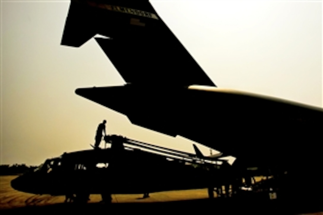 U.S. Air Force airmen and U.S. Army soldiers take the straps off of UH-60 Black Hawk helicopters and cargo aboard a C-17 Globemaster III aircraft on Chaklala Air Force Base, Pakistan, Sept. 1, 2010. The airmen are assigned to the 818th Contingency Response Element and the soldiers are assigned to the 16th Combat Aviation Brigade. Troops will use aircraft to transport supplies throughout the country to aid flood victims.