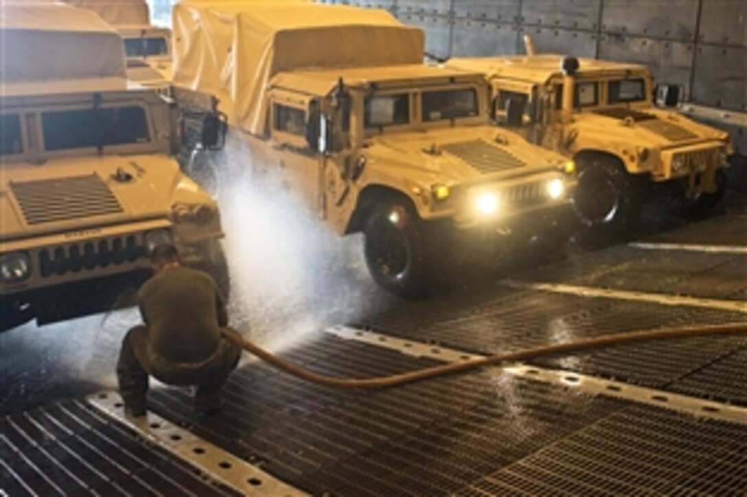 U.S. Marines spray down Humvees while loading the vehicles onto ships belonging to the Kearsarge Amphibious Read Group, off the coast of Onslow Beach, N.C., Aug. 28, 2010. The Marines are assigned to the 26th Marine Expeditionary Unit. The Kearsarge Group is supporting Pakistan flood-relief efforts.