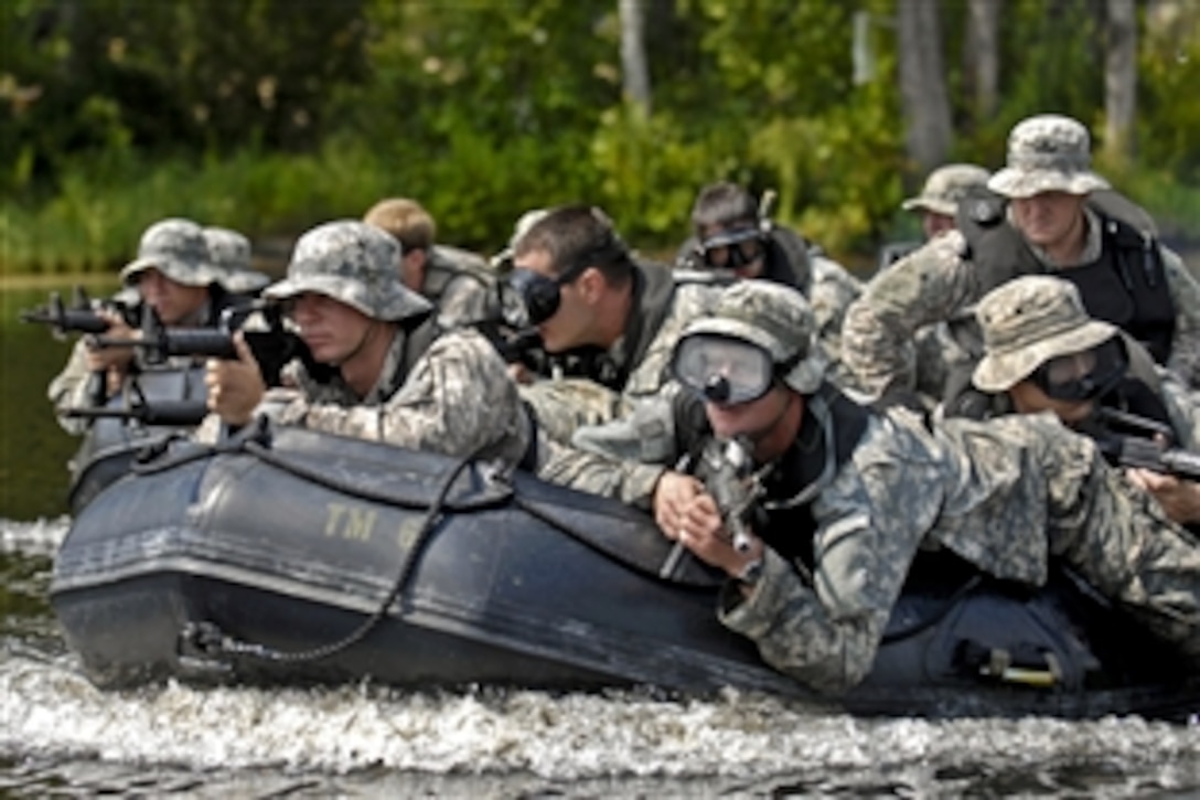 U.S. Army soldiers ride in a zodiac boat and prepare to storm the beach at Mott Lake during their waterborne operations training on Fort Bragg, N.C., Aug. 26, 2010. The soldiers are assigned to Company F, 2nd Battalion, 82nd Combat Aviation Brigade. The training's primary purpose is to ensure all waterborne equipment is operational to respond to a natural disaster.