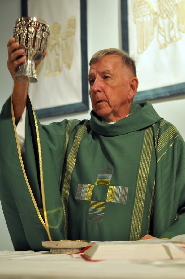 Lt. James Finley, Catholic chaplain for the Marine Corps Air Station in Yuma, Ariz., blesses and prepares the wine for communion during a Catholic Mass at the station chapel Sept. 2, 2010. The 73-year-old New York City-native is the oldest sailor in the service, with 47 years in the priesthood, 20 of it as a Navy chaplain.