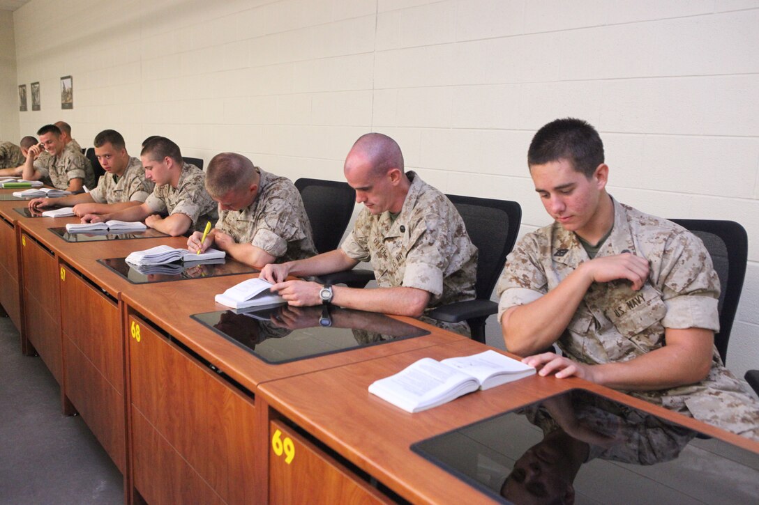 Sailors enrolled in the Chaplain and Religious Program Specialist Expeditionary Skills Training course study Marine Corps knowledge books during a common skills class aboard Camp Johnson, recently.  The eight-week course hones the sailors’ combat skills and immerses them in the Marine Corps lifestyle so they will be better prepared to protect their chaplains, Marines and fellow sailors in combat.