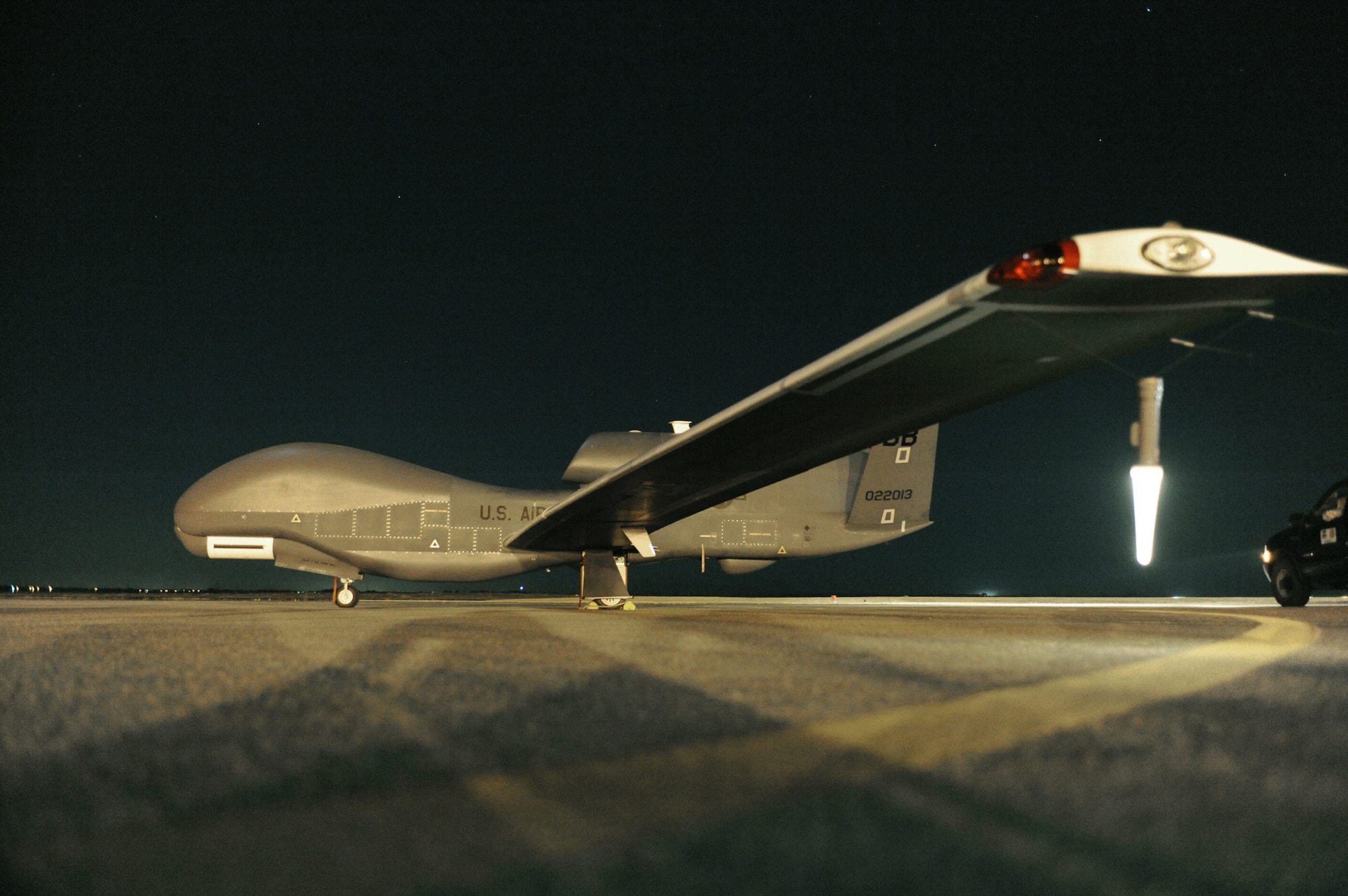 An RQ-4 Global Hawk sits on the runway before beginning a nighttime mission. The aircraft is unmanned, and is used to capture imagery from high altitudes. (Courtesy photo/John Schwab)