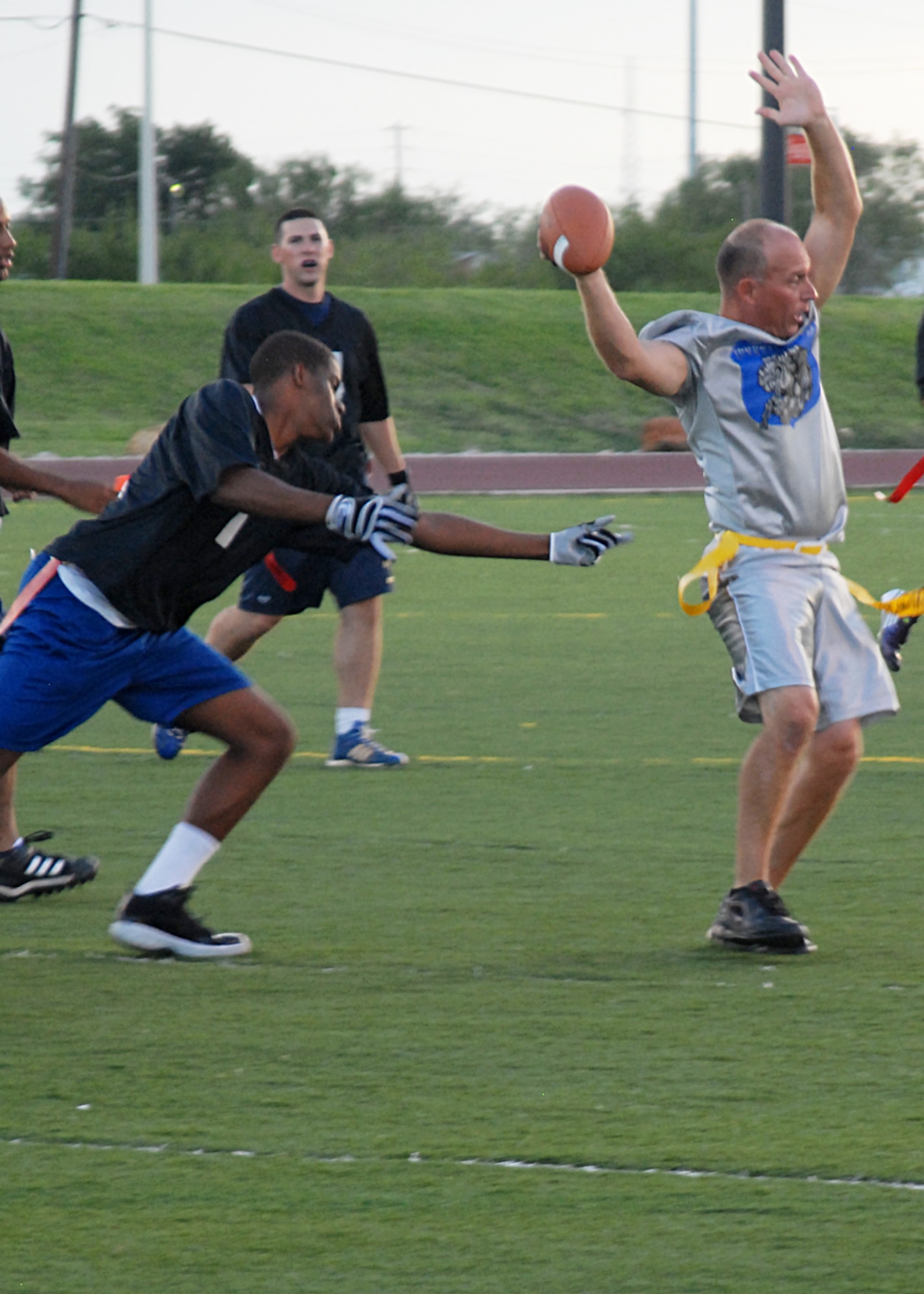 GOODFELLOW AIR FORCE BASE, Texas – Charlie Rehburg, quarterback for the 17th Mission Support Group Junkyard Dogs, spins out of Mark Johnsons' grasps, 316th Training Squadron Sharks, during intramural football at the base football field, Sept. 2. Junkyard Dogs defeated the Sharks 19-6 during intramural play. (U.S. Air Force photo/ Senior Airman Tong Duong)