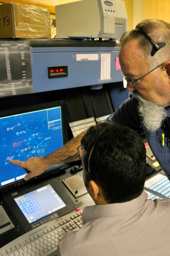 Tom Samples advises an Iraqi air traffic controller, directing the airspace of aircraft traveling through Iraq, Aug. 31, 2010, at Baghdad International Airport. Mr. Samples is contracted by the Iraq Civil Aviation Authority to train and advise Iraqi controllers. The Air Force is turning over airspace control from 15,000 to 24,000 feet in the northern sector of Iraq-known as the Kirkuk sector. (U.S. Air Force photo/Senior Airman Perry Aston)