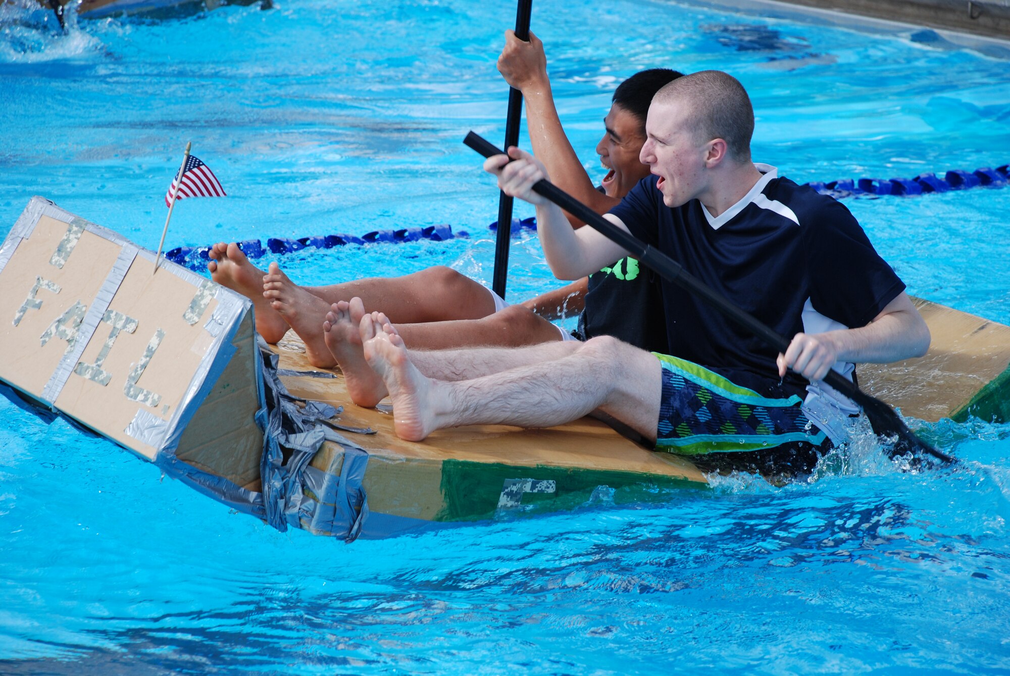 LAUGHLIN AIR FORCE BASE, Texas – Airman 1st Class Jomarie Banaga and Airman Joshua Ewing, both of the 47th Force Support Squadron, compete in the 2010 Laughlin Build-a-Boat Race just before their boat sinks at Friendship Pool here Sept. 2. Competitors were given single-ply cardboard and duct tape as supplies to build their boat and allowed to use nothing else. (U.S. Air Force photo by Airman 1st Class Blake Mize)
