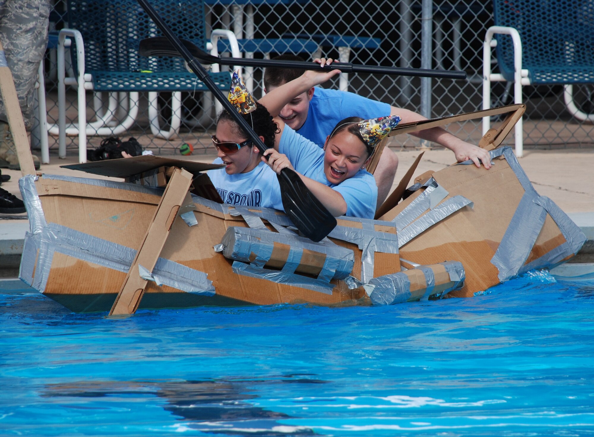 LAUGHLIN AIR FORCE BASE, Texas – Staff Sgt. Irma Ortiz, Airman 1st Class Amy Manibusan and Staff Sgt. Ryan Stine, all of the 47th Communications Squadron, compete in the 2010 Laughlin Build-a-Boat Race just before their boat sinks at Friendship Pool here Sept. 2. The CS team was awarded best sinking by the judges. Competitors were given single-ply cardboard and duct tape as supplies to build their boat and allowed to use nothing else. (U.S. Air Force photo by Airman 1st Class Blake Mize)