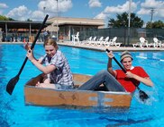 LAUGHLIN AIR FORCE BASE, Texas – Second Lt. Miles Morse and Staff Sgt. Desiree Economides, both of 47th Flying Training Wing public affairs, compete in the 2010 Laughlin Build-a-Boat Race at Friendship Pool here Sept. 2. The PA boat was the only one to remain intact after two full races. Competitors were given single-ply cardboard and duct tape as supplies to build their boat and allowed to use nothing else. (U.S. Air Force photo by Airman 1st Class Blake Mize)