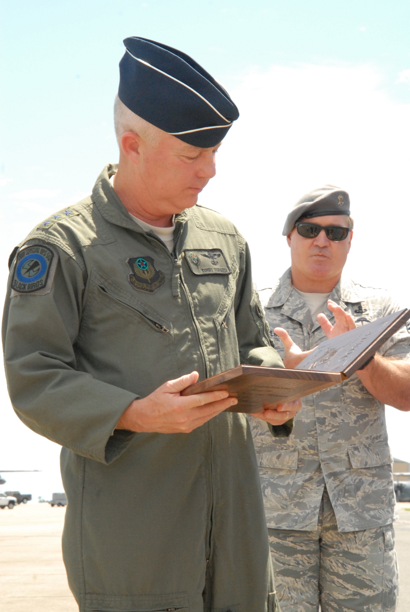 Major General Donald Wurster, AFSOC Commander looks at his award while Chief Master Sgt. Michael Gilbert, AFSOC Command Chief claps on the Hurlburt Field flight line, Aug 31, 2010, Hurlburt Field Fla. Gen. Wurster was just informed that he is to be inducted into the Order of the Sword. The Order of the Sword is the highest honor the enlisted corps can bestow upon an individual and recognizes significant contributions to the enlisted force. The honor was established by the Air Force enlisted corps to recognize and honor senior officers, colonels or above, and civilian equivalents, for conspicuous and significant contributions to the welfare and prestige of the enlisted force and mission effectiveness. General Wurster?s induction is scheduled to take place in a ceremony Nov. 19, 2010. (U. S. Air Force photo by Staff Sgt. Orly N. Tyrell/Released)
