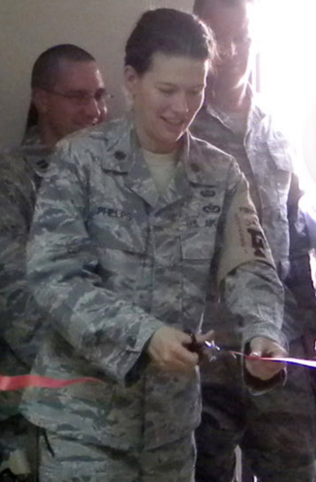 Maj. Jennifer Phelps, 332nd Expeditionary Civil Engineer Squadron engineering flight chief, cuts the ceremonial ribbon at the opening of the first renovation project completed entirely by an Iraqi contractor at Joint Base Balad, Iraq, Aug. 31, 2010.  The 332 ECES and Joint Base Balad Regional Contracting Command oversaw the Iraqi contractor, engineers and craftsman with the goal to build capacity in the local area construction industry. The original four-month timeline to complete the two buildings was cut to 81 days. Capacity building is a critical aspect of the responsible drawdown of forces as the U.S. military works towards its complete departure from Iraq at the end of 2011. (332nd Expeditionary Civil Engineer Squadron courtesy photo)
   