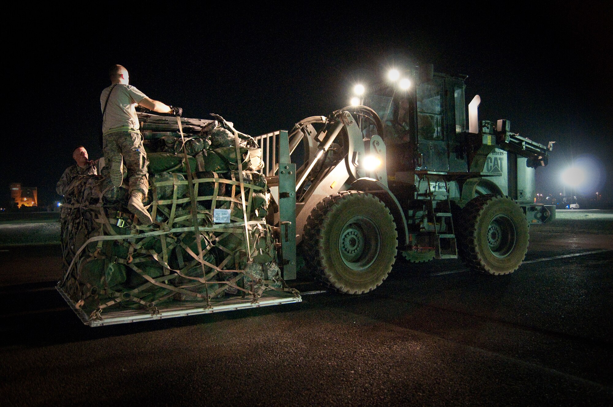 SOUTHWEST ASIA - Airmen from the 386th Aerial Port Squadron place straps on a pallet of cargo before loading it onto a C-130 at an undisclosed air base here Aug. 31, 2010. This particular mission marked the 386th Air Expeditionary Wing's last sortie into Iraq in support of Operation Iraqi Freedom, which officially ended a few hours later. In the past three months alone, the 386th AEW has airlifted more than 74,000 passengers and 1,700 tons of cargo into and out of Iraq aboard C-130s in support of OIF. An additional 82,000 passengers and 34,000 tons of cargo have been carried on C-17s based here. (U.S. Air Force photo by Maj. Dale Greer/Released)