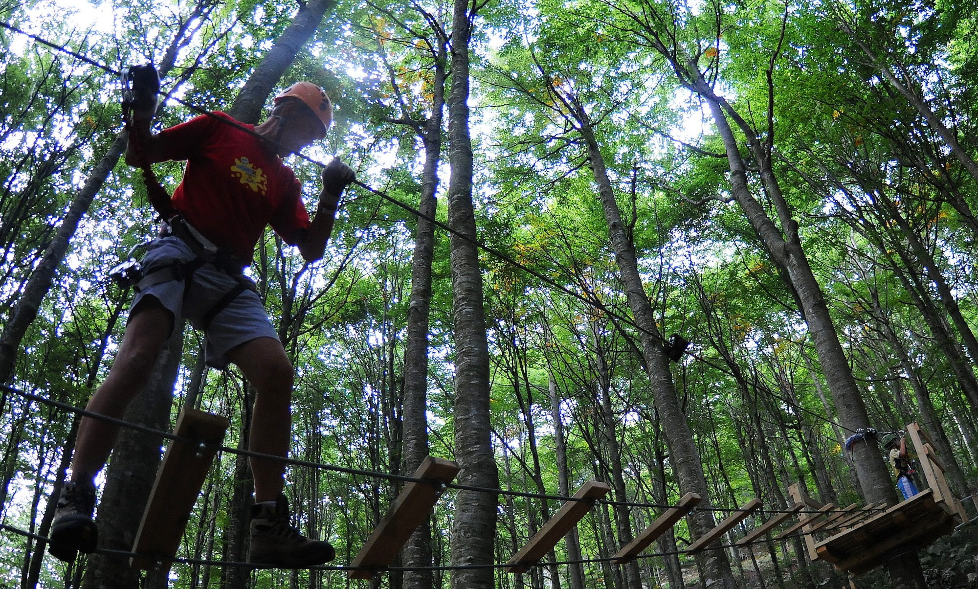 A man crosses a rope bridge at the RampyPark in Piancavallo, Italy. Nestled in the trees, 3,800 feet above Aviano, thrill seekers can harness up for the hours-long aerial obstacle course. (U.S. Air Force photo/Airman 1st Class Katherine Windish)

