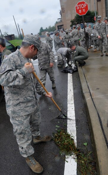 51st Fighter Wing Airmen remove tree branches from parking lots and streets Sept. 3. Airmen from Osan volunteered to help clean up the debris caused by Typhoon Kompasu. (U.S. Air Force photo/Senior Airman Evelyn Chavez)
