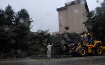 51st Civil Engineer Squadron crews work to clear the streets by clearing power lines, roadways and sidewalks of debris at Osan Sept. 2. Many crews worked throughout the day and night to return hazardous road conditions to normal following Typhoon Kompasu. (U.S. Air Force photo/Senior Airman Evelyn Chavez)