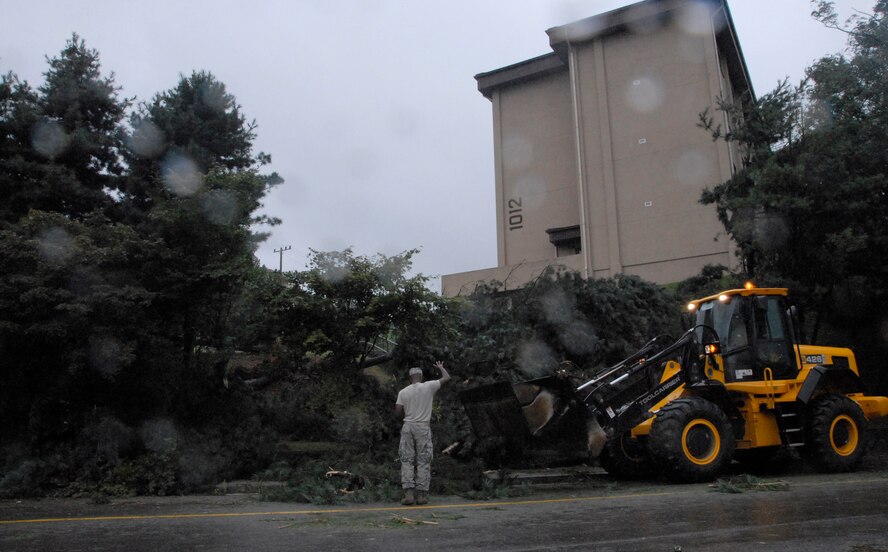 51st Civil Engineer Squadron crews work to clear the streets by clearing power lines, roadways and sidewalks of debris at Osan Sept. 2. Many crews worked throughout the day and night to return hazardous road conditions to normal following Typhoon Kompasu. (U.S. Air Force photo/Senior Airman Evelyn Chavez)