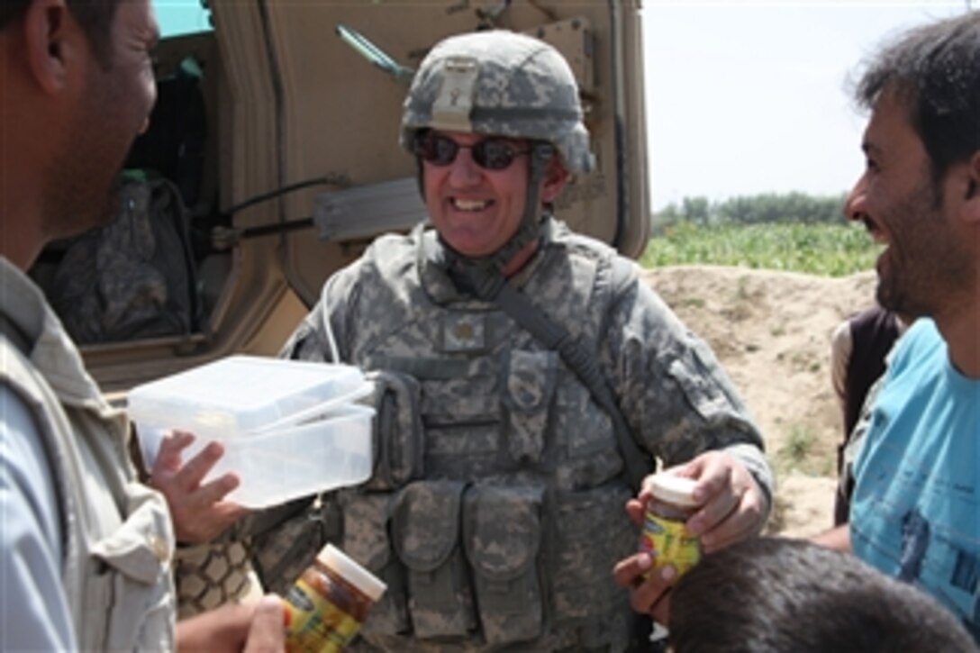 U.S. Army Maj. Michael Gardner, with a civil military support team gives jars of jam to residents in the village of Bahshekel in the Parwan province of Afghanistan on Aug. 29, 2010.  Civil military support team members and a South Korean provincial reconstruction team visited the village to inspect an irrigation site.  