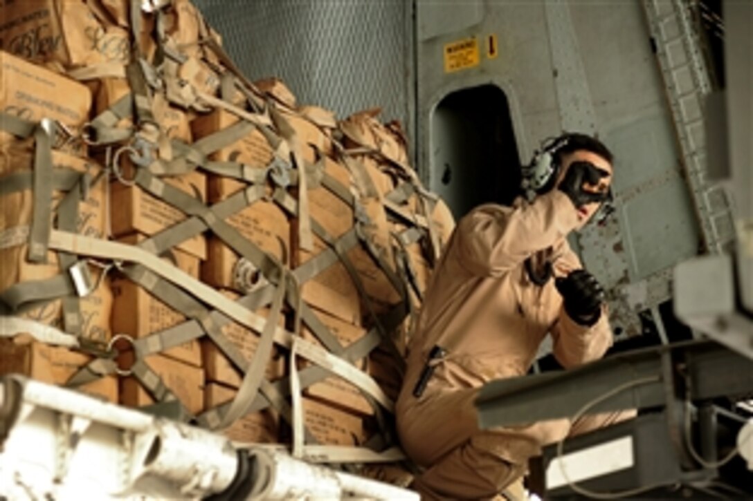 A U.S. Air Force airman signals in the forklift as he offloads supplies aboard his C-5 Galaxy on Chaklala Air Force Base, Pakistan, to support flood relief efforts, Sept. 2, 2010. The airman is a  loadmaster is assigned to the 535th Airlift Squadron, Hickam Air Force Base, Hawaii.