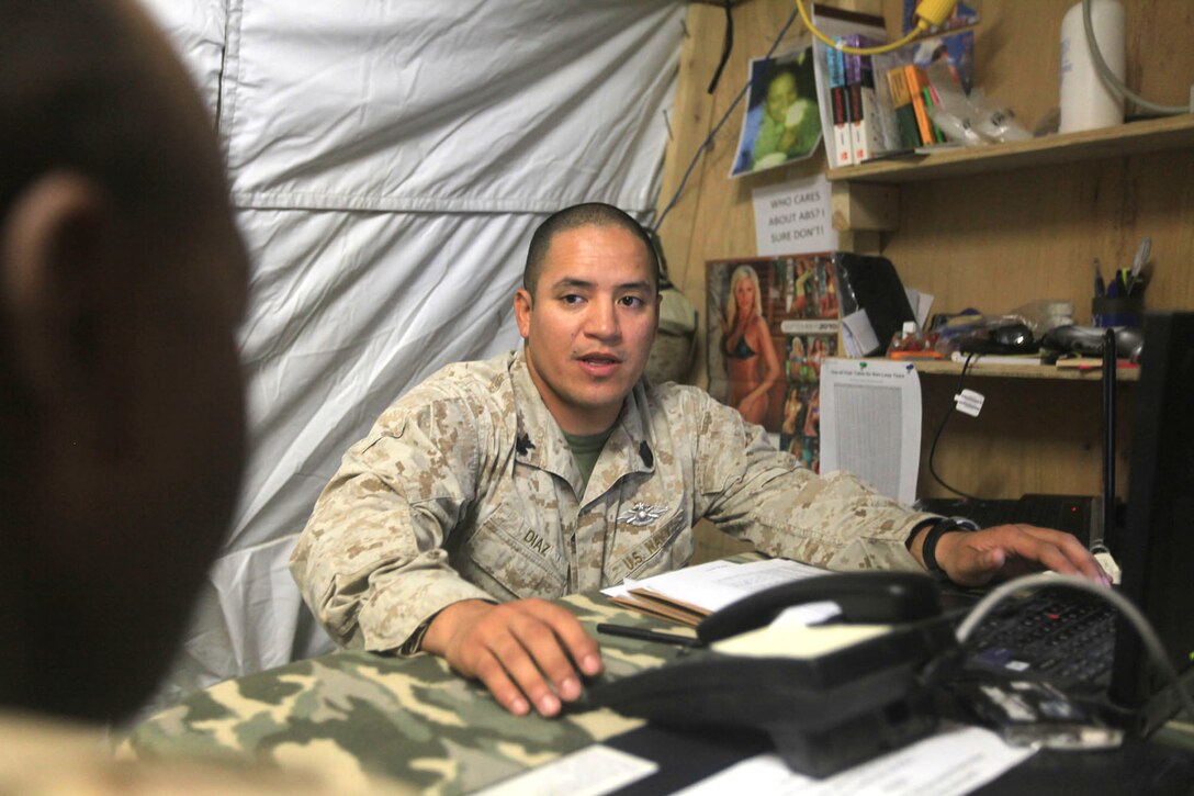 Petty Officer 1st Class Osvaldo Diaz, the Regimental Combat Team 7 independent duty corpsman, sits down with a fellow sailor to conduct his post-deployment health assessment, Sept. 4, 2010, after a yearlong deployment in Afghanistan.
