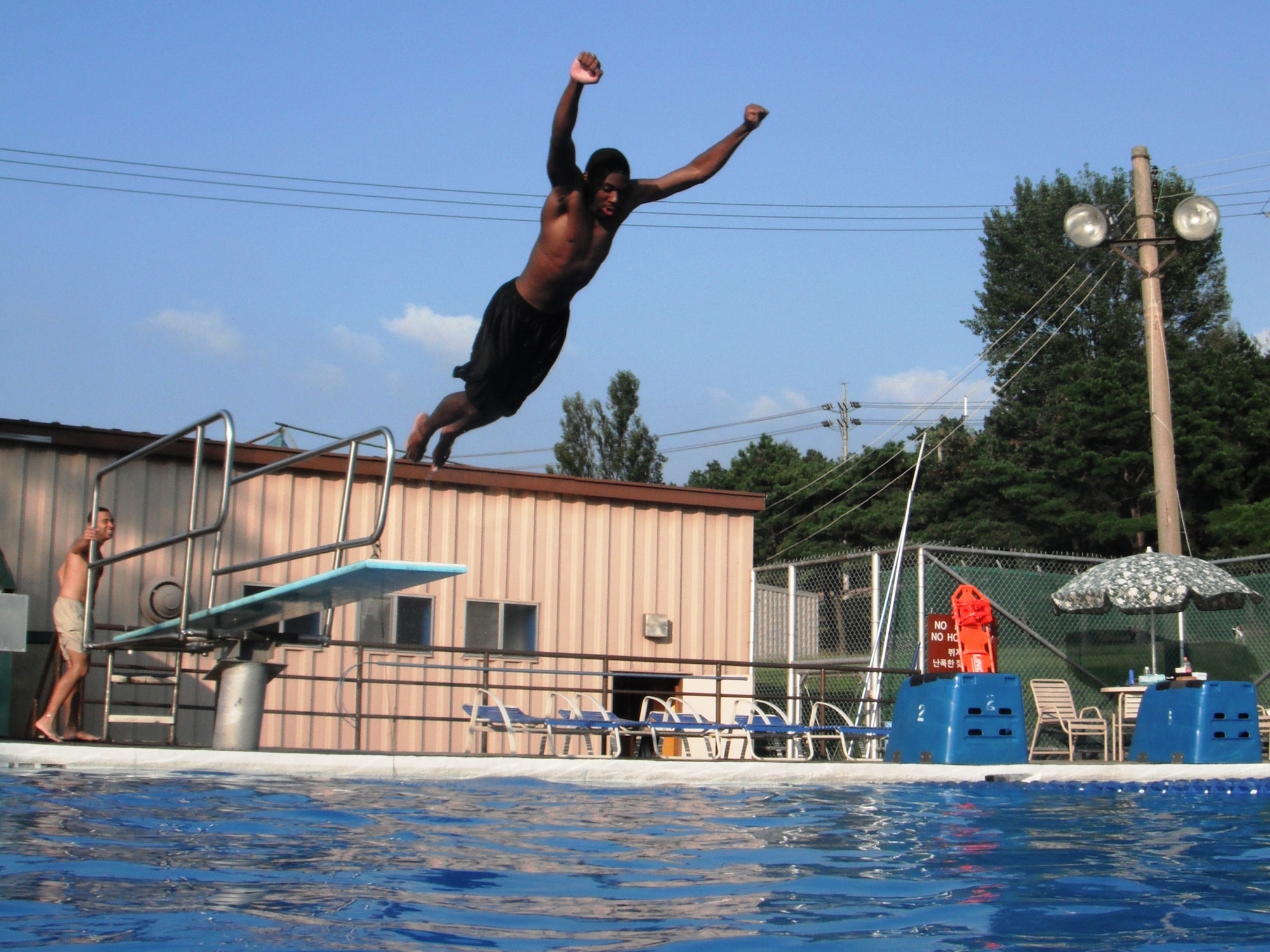 Justin Sieffert and Kenith Isreal, center, take turns diving at Osan’s Defender Pool Sept. 4. The outdoor pool complex remains open through Sept. 7; after that, members of the Team Osan community can swim year-round at the Mustang Indoor Pool. For hours and information, call 784-1452. (U.S. Air Force photo/Staff Sgt. Eric Burks)