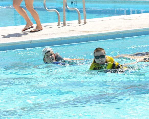 NELLIS AIR FORCE BASE, NEV.--  Airman 1st Class Angelo Cavanitta and Airman 1st Class Thomas Holden, representing the Crosswinds dining facility, swim to the finish line, dragging their sunken boat behind them Sept. 2. (U.S Air Force Photo by Senior Airman Stephanie Rubi)