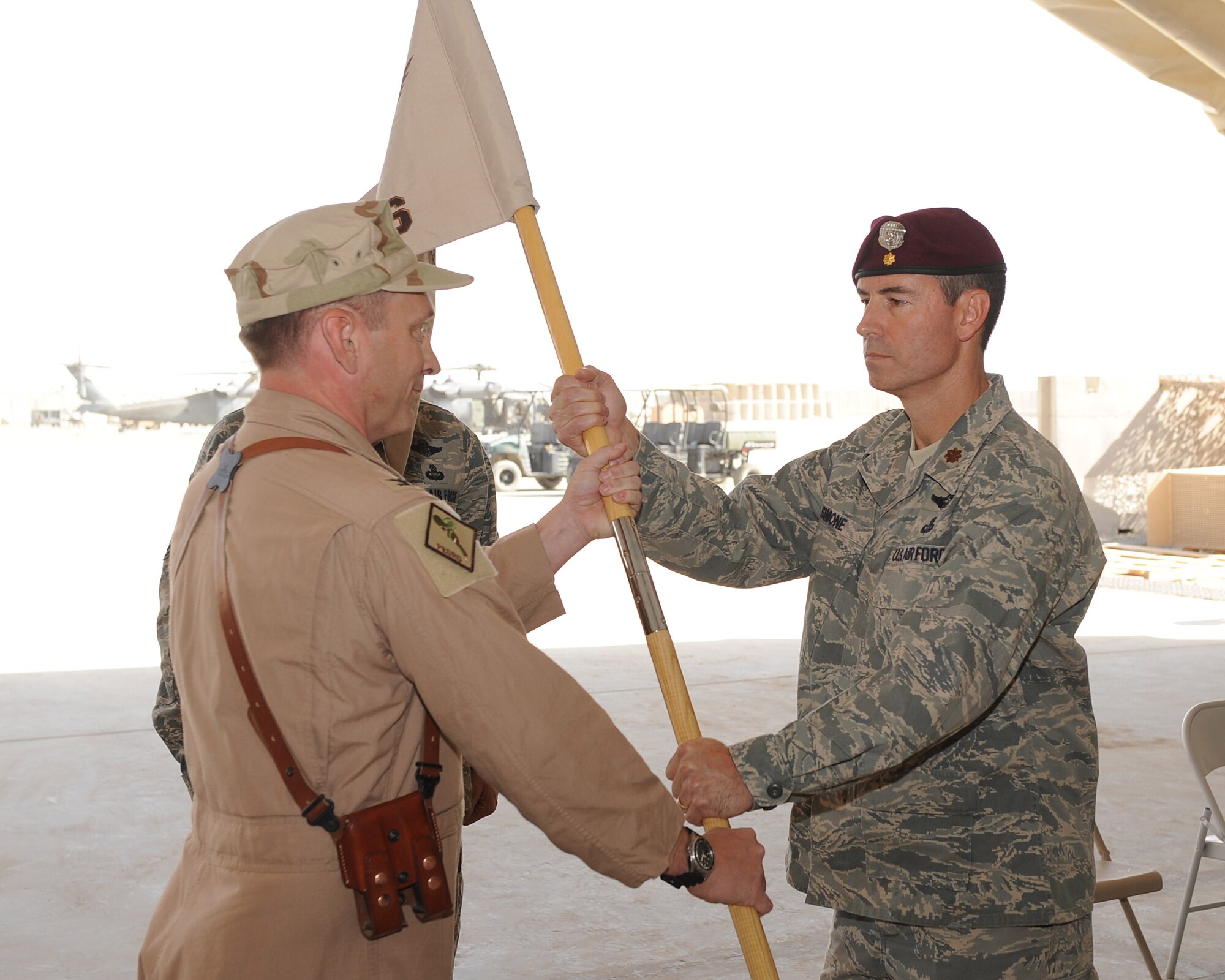 Maj. Steven Simone assumes command of the 46th Expeditionary Rescue Squadron by accepting the guidon from Col. David Hicks, commander of the 451st Expeditionary Operations Group on Sept. 2, 2010 at Camp Bastion, Afghanistan.  Major Simone is the commander of the 46th ERQS and is deployed from the 38th Rescue Squadron, Moody Air Force Base, Ga. (U.S. Air Force photo by Tech. Sgt. Chad Chisholm/Released)