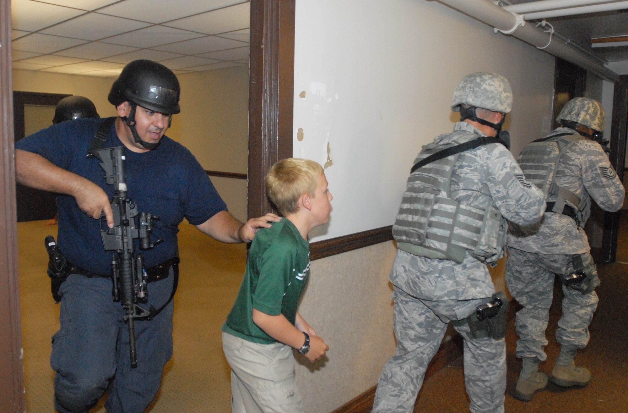 JOINT BASE PEARL HARBOR HICKAM, Hawaii - 647th Security Forces Squadron Airmen and an immigration customs enforcement officer based out of Oahu practice bringing a child “hostage” to safety during a in High Risk Response course here,  Sept. 2. The active shooter scenario they received is now necessary in part because of the Ft. Hood, Texas, shootings which occurred in November 2009. (U.S. Air Force photo/Staff Sgt. Carolyn Viss) 
