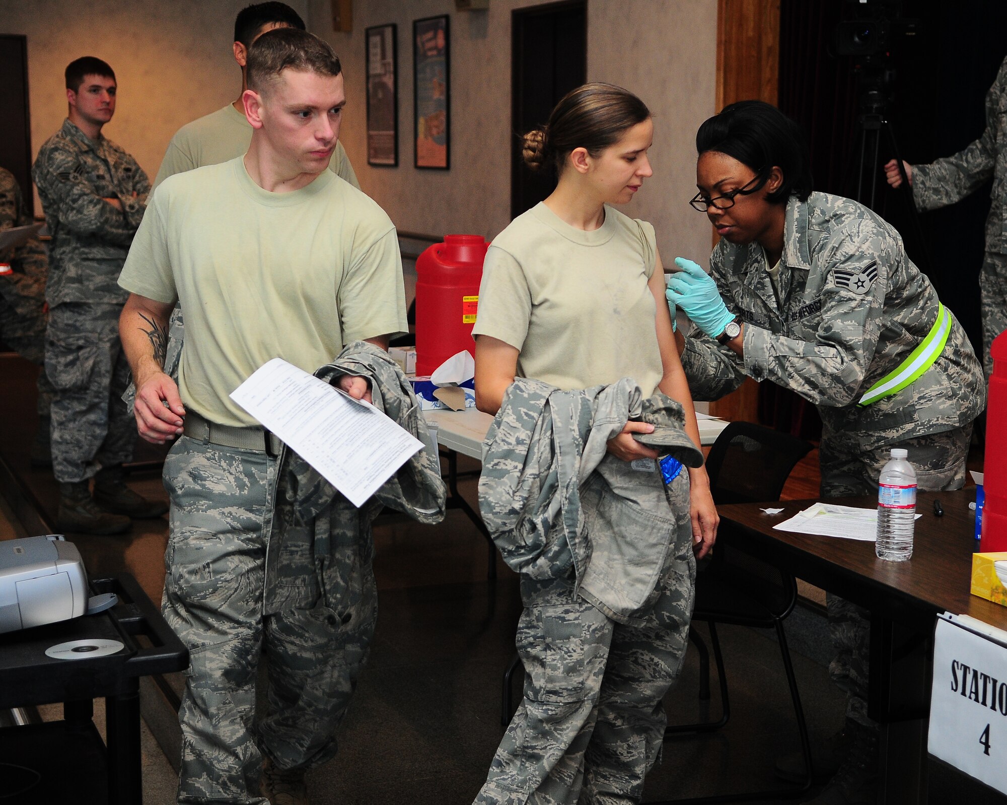 YOKOTA AIR BASE, Japan -- Senior Airman Tiffany Roberts, an allergy/immunization medical technician from the 374th Medical Operations Squadron, administers the flu shot to Airman Marie Lumives, from the 374th Aircraft Maintenance Squadron. Active duty members lined up to receive either the nasal or inject-able flu and H1N1 vaccine at the Airmen and Family Readiness Center, here September 7. Every active duty member on base is required to get the flu shot annually. This prevents the virus from spreading across base and ensures the mission continues. (U.S. Air Force photo by: Staff Sgt Stacy Moless)