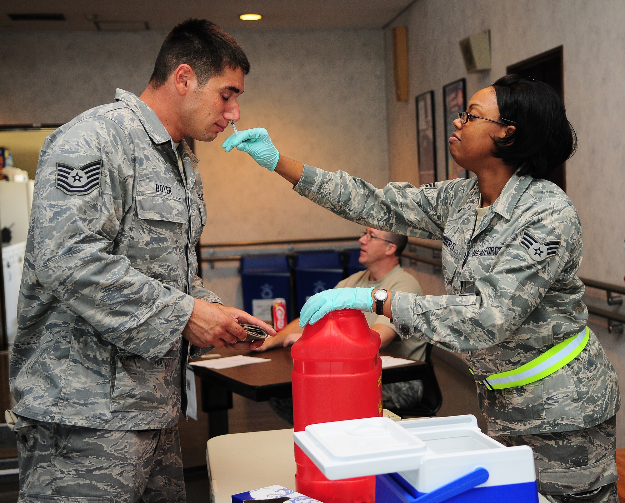 YOKOTA AIR BASE, Japan -- Senior Airman Tiffany Roberts, an allergy/immunization medical technician from the 374th Medical Operations Squadron, administers a flu shot to Technical Sgt Cory Boyer, from the 374th Aircraft Maintenance Squadron. Medical personnel set up at the Airmen and Family Readiness Center, here September 7, as a part of a Point of Distribution plan to vaccinate a large portion of the active duty population. Getting the flu shot helps to prevent the virus from spreading across base and ensures the mission continues. (U.S. Air Force photo by: Staff Sgt Stacy Moless)