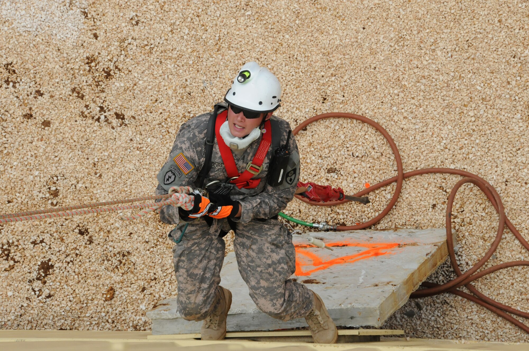 Specialist Doren, a member of the California National Guards Chemical, Biological,  Radialogical/Nuclear, and Explosive Enhanced Force Pakage Team, is lowered over the side of a three story building in order to extract a victim traped in a mock parking garage collapse during Vigilant Guard Guam, Aug. 25, 2010 (U.S. Air Force photo by Tech Sgt Charles Vaughn)(released)