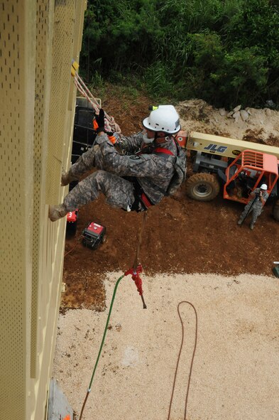 Specialist Doren, a member of the California National Guards Chemical, Biological,  Radialogical/Nuclear, and Explosive Enhanced Force Pakage Team, is lowered over the side of a three story building in order to extract a victim traped in a mock parking garage collapse during Vigilant Guard Guam, Aug. 25, 2010 (U.S. Air Force photo by Tech Sgt Charles Vaughn)(released)