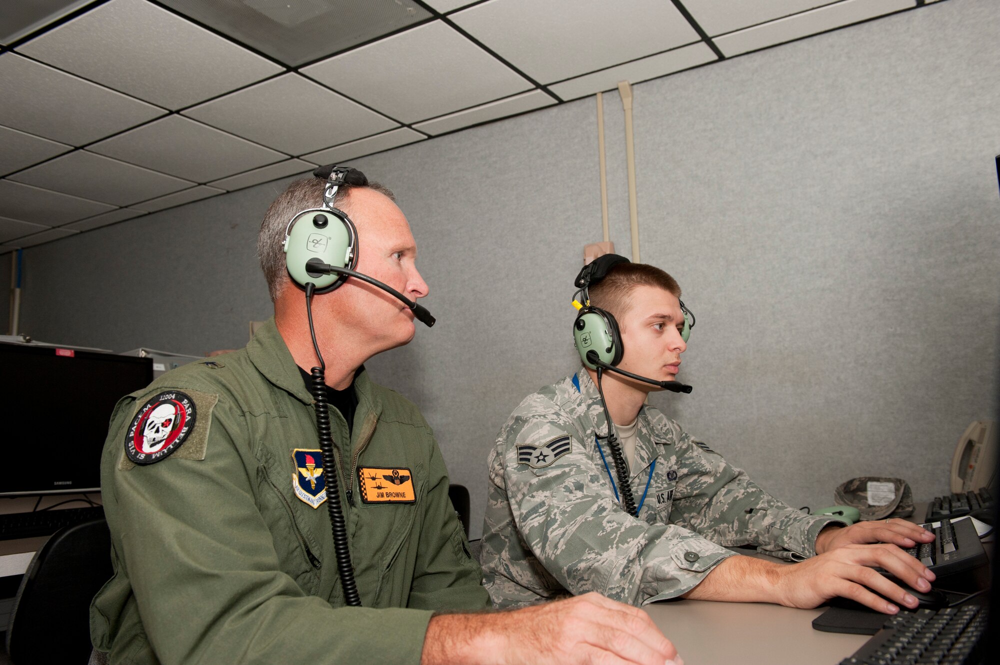 Brigadier Gen. James Browne, 325th Fighter Wing commander, Senior Airman Eric Parker, 325th Air Control Squadron Pilot Simulator Trainer, as he conducts a simulation as part of the Commander’s Shadow Program Sept. 3.