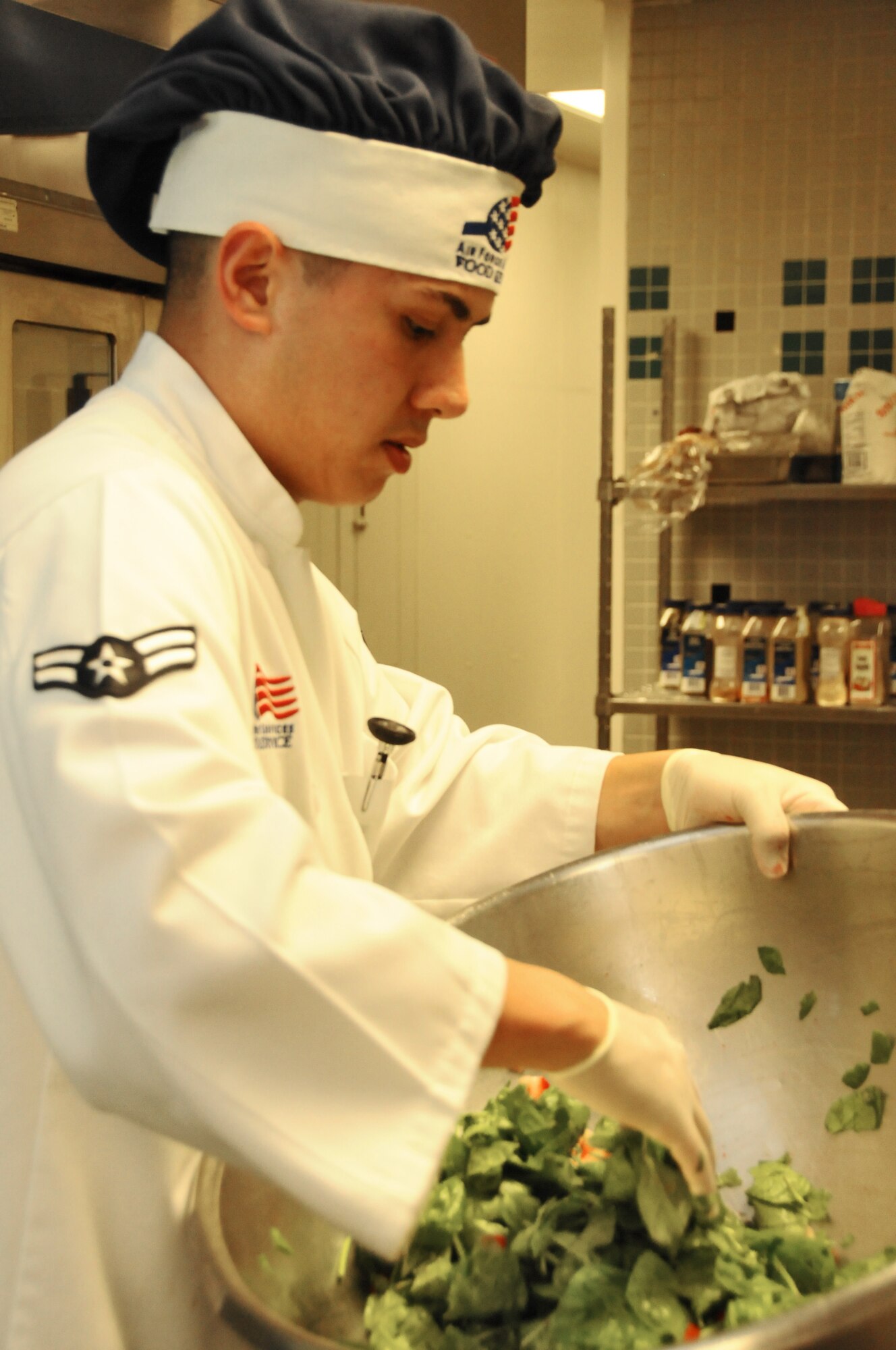 Airman 1st Class Ray Cox, 1st Special Operations Force Support Squadron food service specialist, mixes a salad during the Chef of the Quarter competition at the Reef Dining Facility at Hurlburt Field, Fla., Aug. 31, 2010. The 1st SOFSS holds the competition each quarter for Airmen to demonstrate their cooking abilities and talents.  (Courtesy photo by Barbara Fuller)