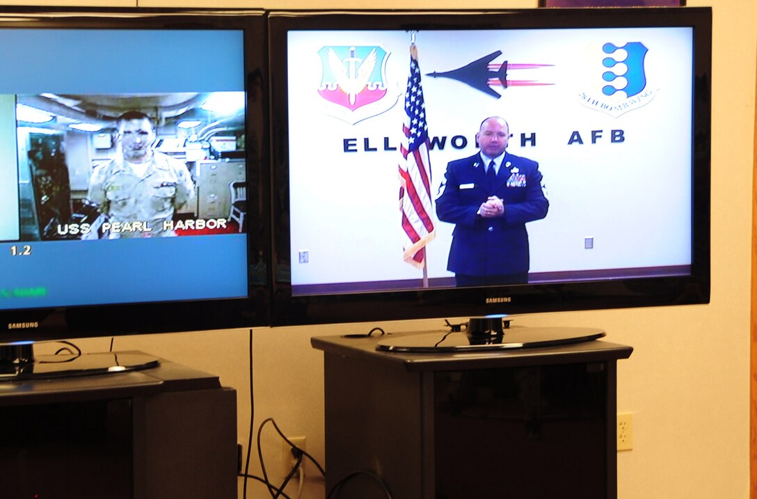 ELLSWORTH AIR FORCE BASE, S.D. -- (Right) Chief Master Sgt. Brian Lavoie, 28th Operations Group superintendent, takes the Oath of Enlistment over a teleconference, Aug. 27.  Chief Lavoie had the opportunity to be reenlisted at Ellsworth by his son, U.S. Navy Ensign Paul Lavoie, who swore him in from the U.S.S. Pearl Harbor. (U.S. Air Force photo/Airman 1st Class Anthony Sanchelli)