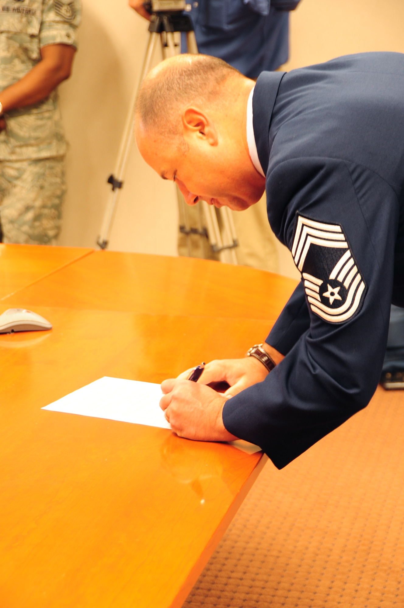 ELLSWORTH AIR FORCE BASE, S.D. -- Chief Master Sgt. Brian Lavoie, 28th Operations Group superintendent, signs the Oath of Enlistment for another four years, Aug. 27.  Chief Lavoie was sworn in by his son, U.S. Navy Ensign Paul Lavoie, aboard the U.S.S. Pearl Harbor at sea, via a video teleconference. (U.S. Air Force photo/Airman 1st Class Anthony Sanchelli)