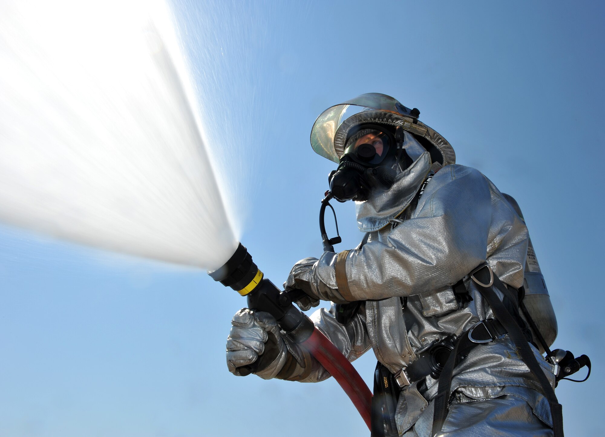Staff Sgt. Benjamen Morin, 19th Civil Engineer Squadron fire protection crew chief, sprays water from a hand-line connected to a P19H fire truck Aug. 24. The Air Force base currently has 58 firefighters assigned and operates 24 hours a day, seven days a week. (U.S. Air Force photo by Staff Sgt. Chris Willis)