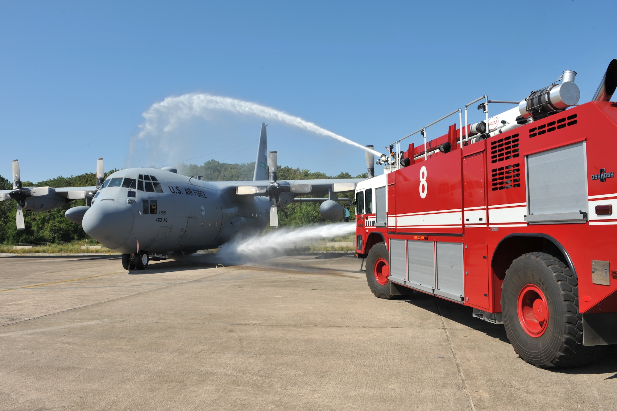 Firefighters practice extinguishing a C-130 with a P-19H fire truck Aug. 24 during a simulated fire response. The fire department has 12 trucks assigned. The P19H is unique because the nozzle can puncture an aircraft and has a 60-foot reach. (U.S. Air Force photo by Staff Sgt. Chris Willis)