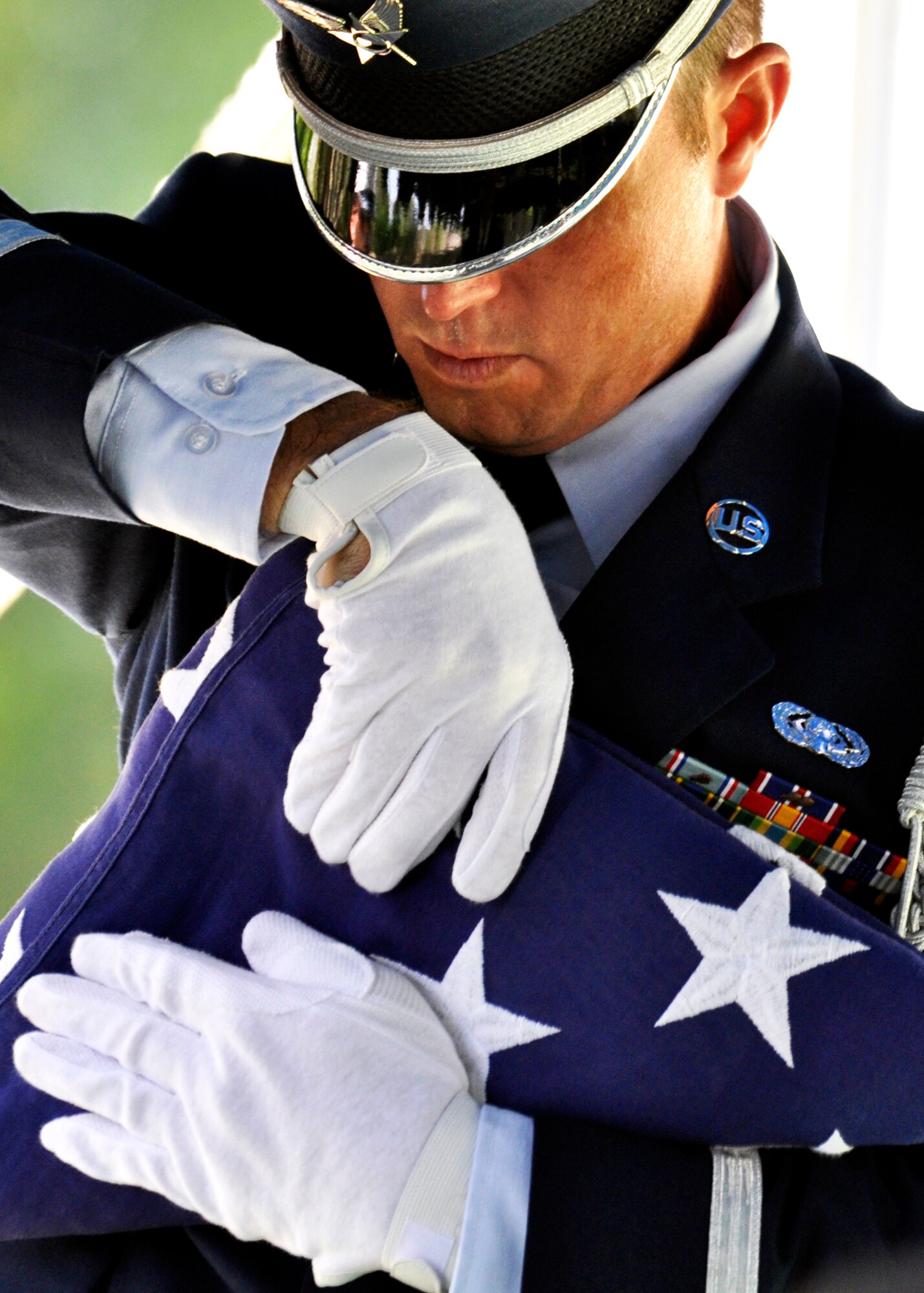 Staff Sgt. John Horgos, Eglin honor guard, adjusts the folds of the flag during a mock funeral as part of the honor guard graduation Sept. 3.  The class performs a funeral ceremony with full honors for base leadership before graduating afterward.  The ceremony has four honor guard functions to be performed:  the flag detail, the 21-gun salute, pall bearers and bugler.  Eglin’s honor guard holds four classes per year with 15 Airmen graduating this particular class.  (U.S. Air Force photo/Samuel King Jr.)