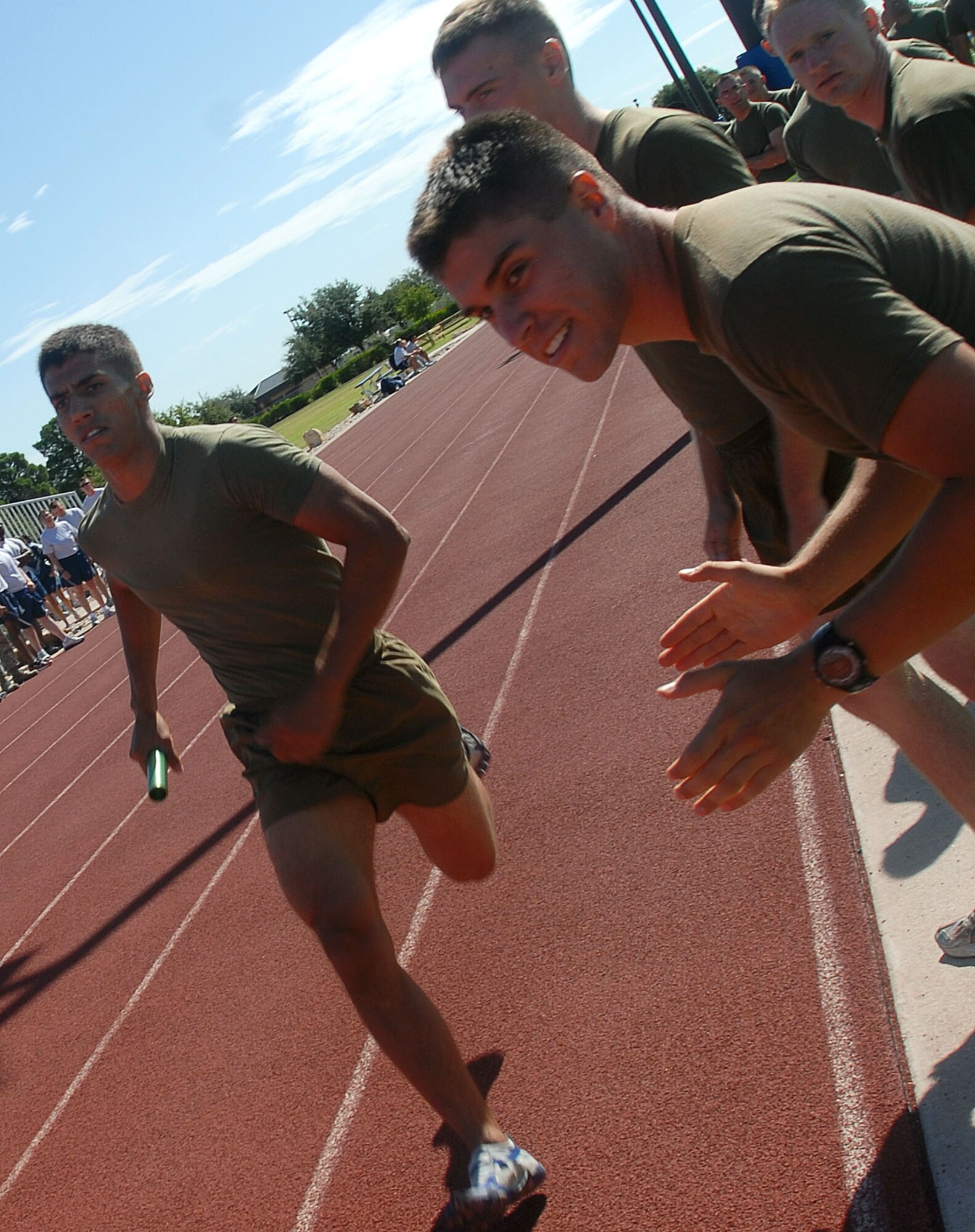 Members of the U.S. Marine Corps Detatchment here support their team during the two mile relay race here Sept. 3 as part of Sports Day. The team, which consisted of four runners, won the relay. (U.S. Air Force photo/Airman 1st Class Jessica D. Keith)